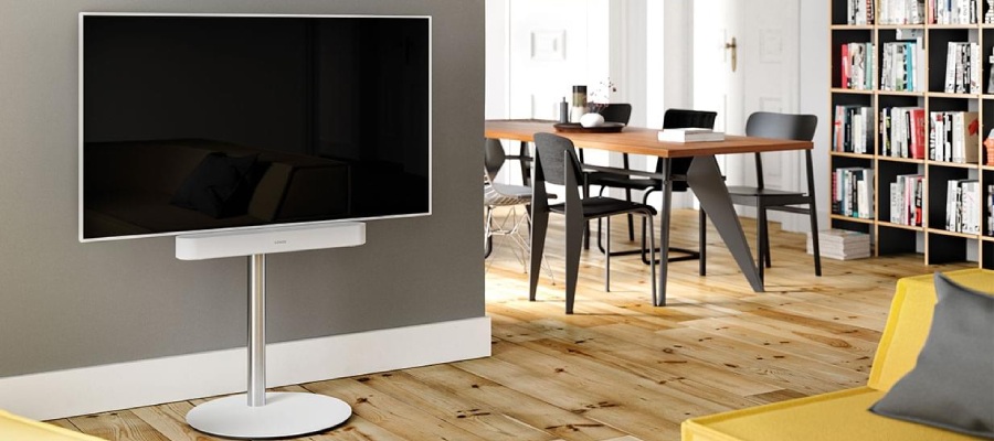 Hvid tv på et hvidt stativ med en hvid soundbar i stuen.